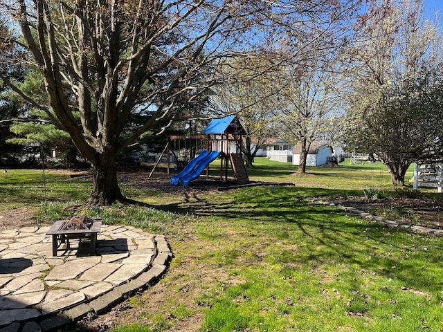 view of yard with a patio, a playground, and an outdoor fire pit