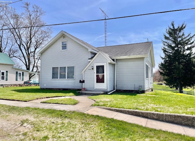 bungalow featuring a shingled roof and a front lawn
