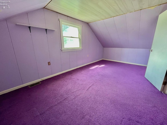 additional living space with lofted ceiling, visible vents, and carpet