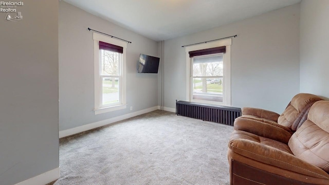 sitting room with baseboards, radiator heating unit, carpet flooring, and plenty of natural light