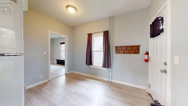 interior space featuring baseboards and light wood-style flooring