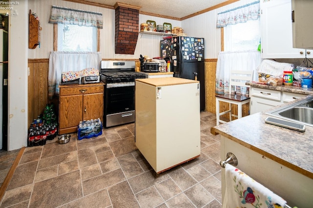 113 W Grant St, Clyde, OH 43410 - kitchen with gas stove, wooden walls, ornamental molding, and a wealth of natural light