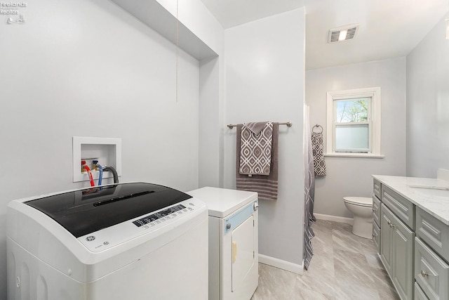 laundry room with visible vents, washer and clothes dryer, laundry area, and baseboards
