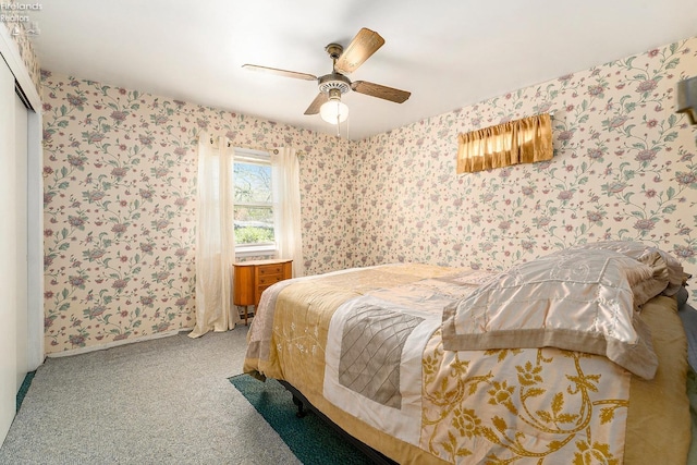 carpeted bedroom featuring baseboards, wallpapered walls, ceiling fan, and a closet