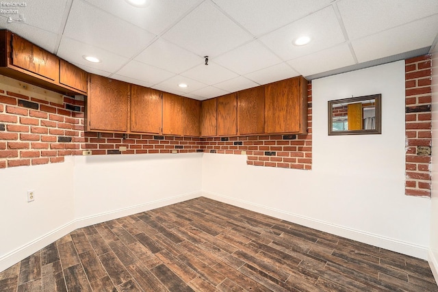 unfurnished room featuring recessed lighting, a paneled ceiling, dark wood-style floors, and baseboards