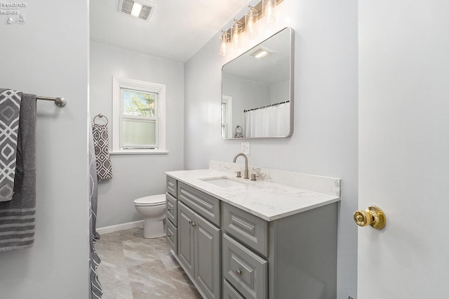 bathroom with toilet, visible vents, vanity, and baseboards