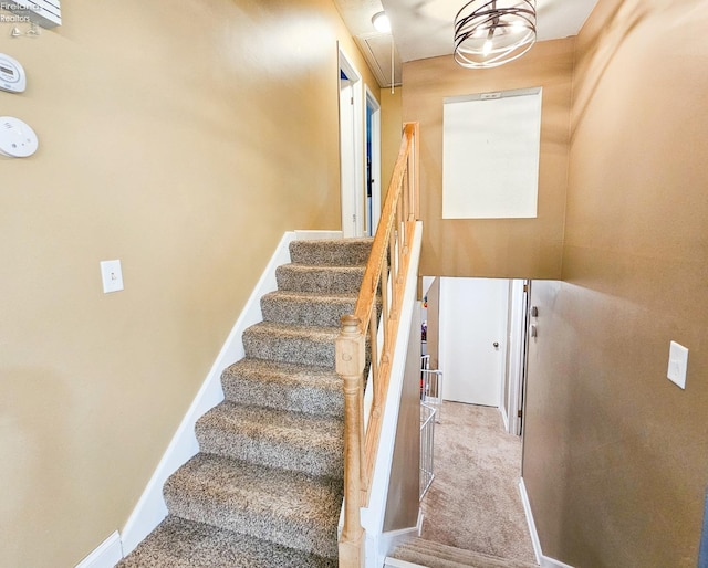 staircase with attic access, baseboards, and carpet flooring