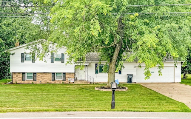 tri-level home with an attached garage, a front lawn, and concrete driveway