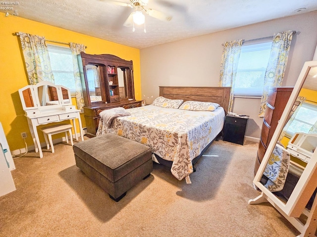 carpeted bedroom featuring a textured ceiling, baseboards, and ceiling fan