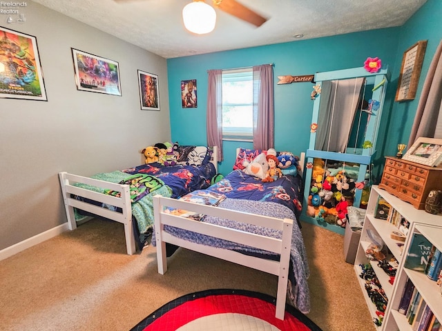 bedroom with carpet, a textured ceiling, and baseboards
