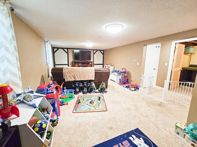 recreation room with carpet and a textured ceiling