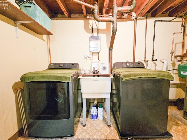 laundry area with laundry area, a sink, and washer and clothes dryer