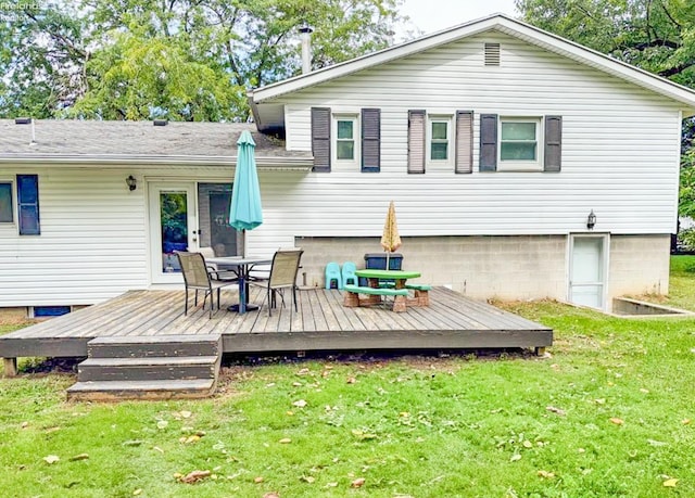 rear view of property with a lawn, a deck, and outdoor dining space