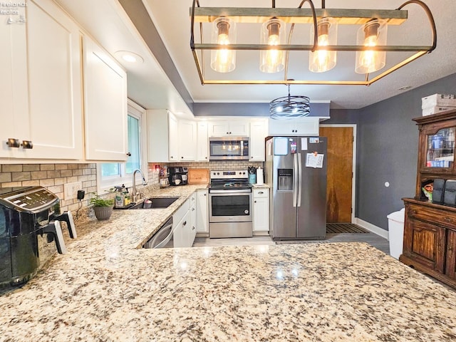 kitchen featuring light stone countertops, stainless steel appliances, a sink, and tasteful backsplash