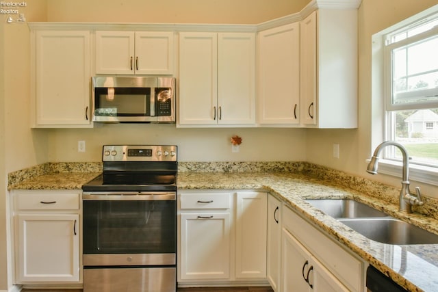 4340 E Mckenna Ln, Port Clinton, OH 43452 - kitchen featuring stainless steel appliances, a sink, healthy amount of natural light, and white cabinetry