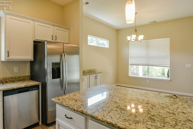 4340 E Mckenna Ln, Port Clinton, OH 43452 - kitchen featuring appliances with stainless steel finishes, white cabinetry, light stone countertops, a chandelier, and hanging light fixtures