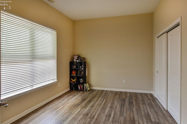 4340 E Mckenna Ln, Port Clinton, OH 43452 - unfurnished bedroom with wood finished floors, a closet, and baseboards