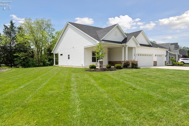 4340 E Mckenna Ln, Port Clinton, OH 43452 - view of front of house featuring an attached garage, a front lawn, driveway, and stone siding