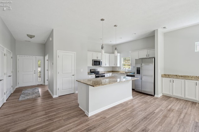 4340 E Mckenna Ln, Port Clinton, OH 43452 - kitchen featuring stainless steel appliances, a sink, white cabinetry, a kitchen island, and wood finished floors