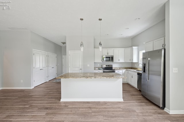 4340 E Mckenna Ln, Port Clinton, OH 43452 - kitchen with appliances with stainless steel finishes, a center island, white cabinets, light wood-style floors, and hanging light fixtures