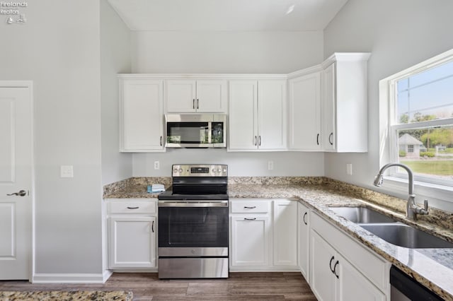 4340 E Mckenna Ln, Port Clinton, OH 43452 - kitchen featuring stainless steel appliances, a sink, dark wood-style flooring, and white cabinetry