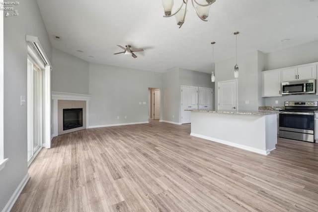4340 E Mckenna Ln, Port Clinton, OH 43452 - unfurnished living room with light wood-type flooring, baseboards, ceiling fan, and a glass covered fireplace