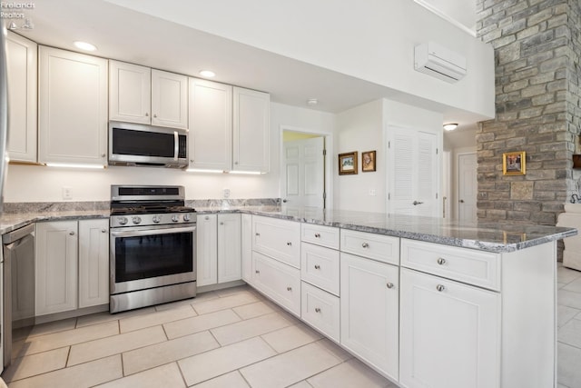 2951 N Chickadee Prt, Clinton, OH 43452 - kitchen with light stone countertops, white cabinetry, a peninsula, stainless steel appliances, and light tile patterned flooring