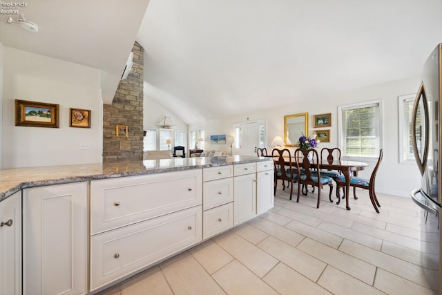 2951 N Chickadee Prt, Clinton, OH 43452 - kitchen featuring a healthy amount of sunlight, freestanding refrigerator, vaulted ceiling, and white cabinetry