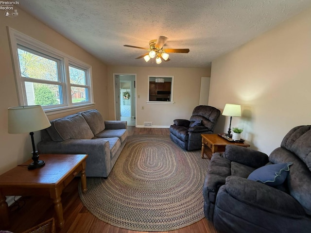 120 Schiller Ave, Sandusky, OH 44870 - living area featuring a ceiling fan, wood finished floors, a textured ceiling, baseboards, and visible vents