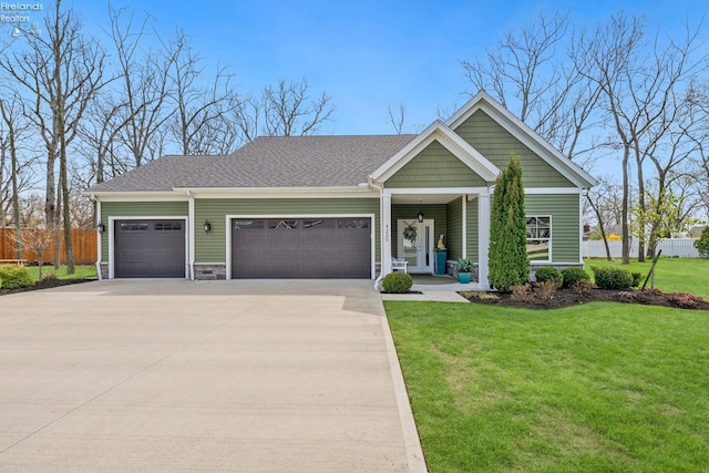 4220 Mckenna Ln, Port Clinton, OH 43452 - view of front of house with fence, a shingled roof, an attached garage, driveway, and a front yard