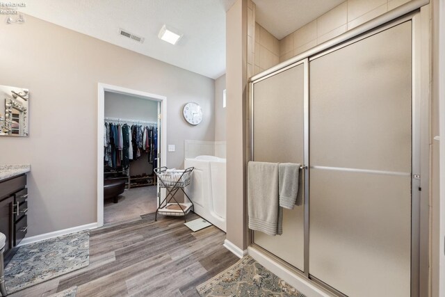4220 Mckenna Ln, Port Clinton, OH 43452 - full bath featuring a bath, wood finished floors, visible vents, and a shower stall