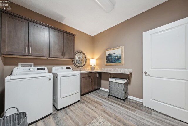4220 Mckenna Ln, Port Clinton, OH 43452 - laundry area featuring washing machine and clothes dryer, baseboards, light wood-type flooring, and cabinet space
