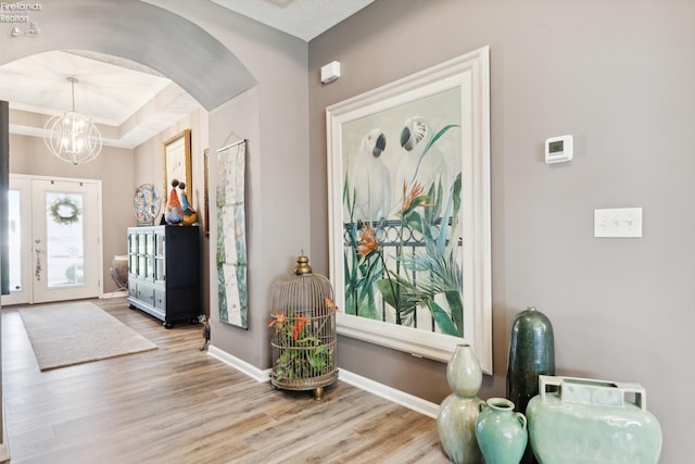 4220 Mckenna Ln, Port Clinton, OH 43452 - entrance foyer featuring arched walkways, wood finished floors, baseboards, and an inviting chandelier