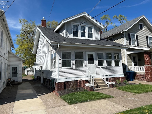 701 Polk St, Sandusky, OH 44870 - bungalow featuring a chimney, a shingled roof, and entry steps