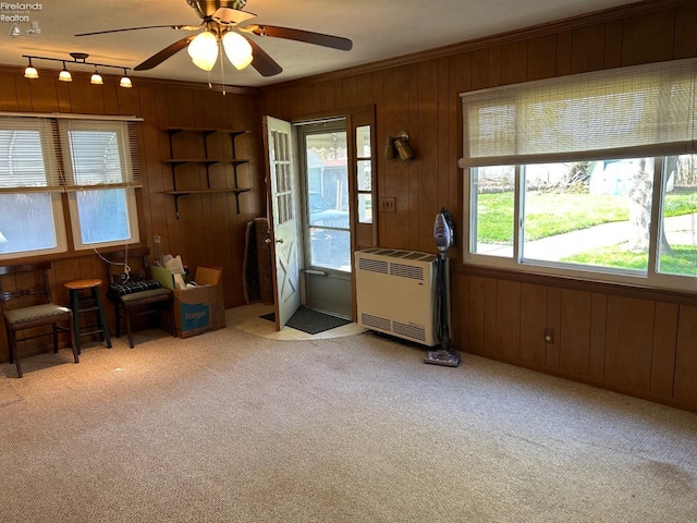 701 Polk St, Sandusky, OH 44870 - interior space featuring carpet, heating unit, ceiling fan, crown molding, and wooden walls