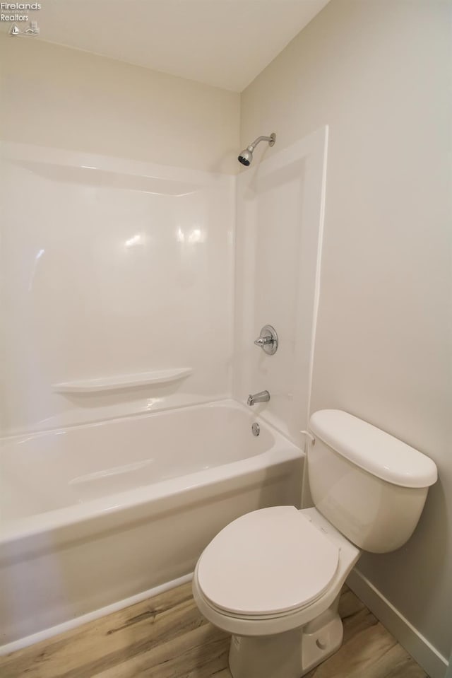 624 Shumaker Dr, Bellevue, OH 44811 - bathroom featuring shower / bathing tub combination, wood finished floors, toilet, and baseboards