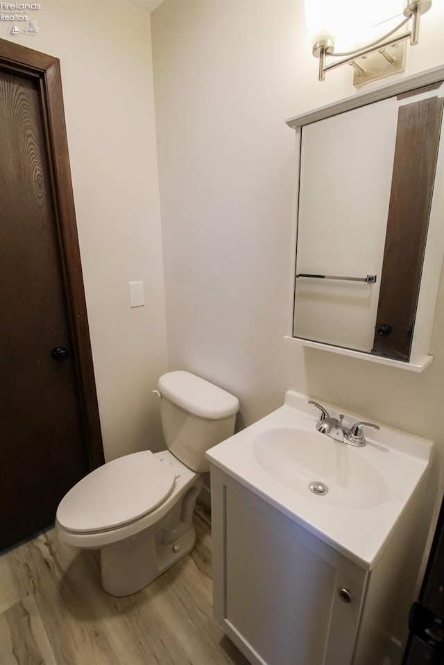 624 Shumaker Dr, Bellevue, OH 44811 - half bath with toilet, vanity, and wood finished floors