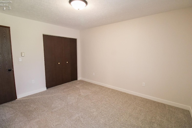 624 Shumaker Dr, Bellevue, OH 44811 - unfurnished bedroom with light colored carpet, baseboards, a textured ceiling, and a closet