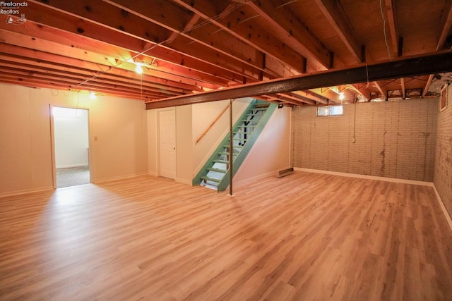 624 Shumaker Dr, Bellevue, OH 44811 - basement featuring baseboards, wood finished floors, stairs, and brick wall