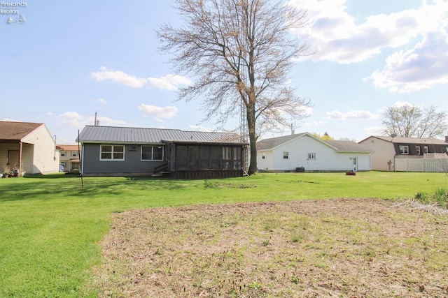 624 Shumaker Dr, Bellevue, OH 44811 - back of property with metal roof, a sunroom, and a lawn