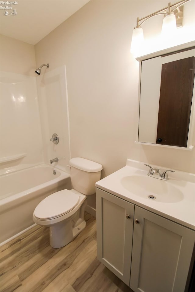 624 Shumaker Dr, Bellevue, OH 44811 - full bath featuring wood finished floors, toilet, vanity, and bathing tub / shower combination