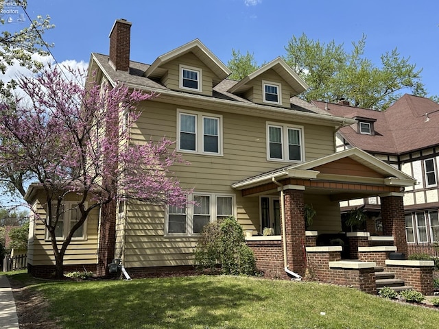 123 E Main, Norwalk, OH 44857 - view of front of home featuring a front lawn, covered porch, and a chimney