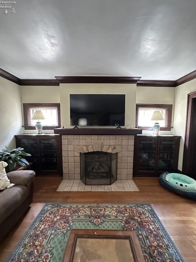 123 E Main, Norwalk, OH 44857 - living area with crown molding, a tile fireplace, and wood finished floors
