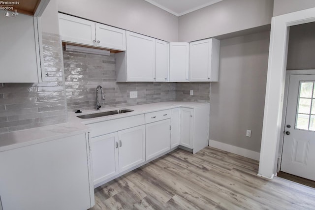2615 Columbus Ave, Sandusky, OH 44870 - kitchen featuring white cabinetry, light countertops, light wood-style floors, and a sink