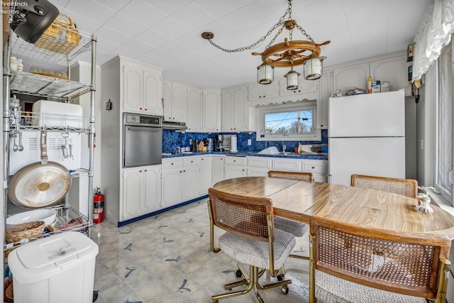 1270 Deist Rd, Middle Bass Island, OH 43446 - kitchen featuring dark countertops, wall oven, freestanding refrigerator, under cabinet range hood, and light floors