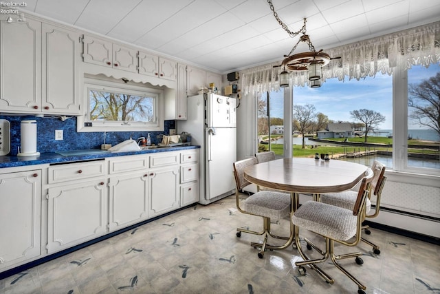1270 Deist Rd, Middle Bass Island, OH 43446 - kitchen with tasteful backsplash, a baseboard radiator, freestanding refrigerator, white cabinets, and dark countertops