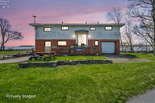 1270 Deist Rd, Middle Bass Island, OH 43446 - bi-level home with a garage, brick siding, aphalt driveway, and a front lawn