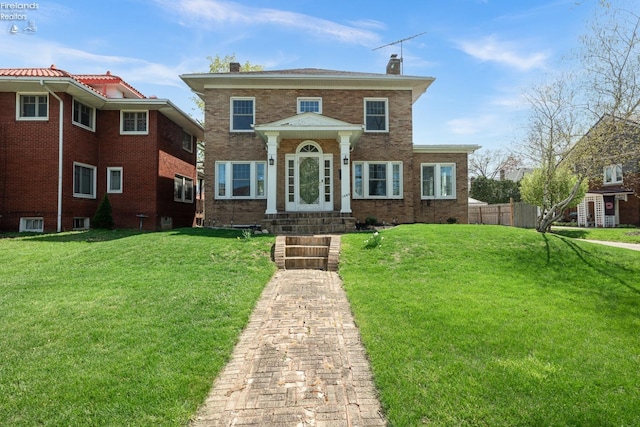 1507 S Lakeview Blvd, Lorain, OH 44052 - view of front of house featuring a front lawn, fence, brick siding, and a chimney