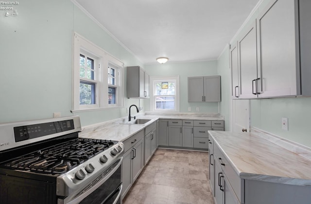 1507 S Lakeview Blvd, Lorain, OH 44052 - kitchen with gray cabinetry, ornamental molding, gas stove, and a sink