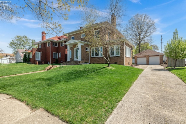 1507 S Lakeview Blvd, Lorain, OH 44052 - view of front of home featuring a chimney, brick siding, an outbuilding, a detached garage, and a front lawn
